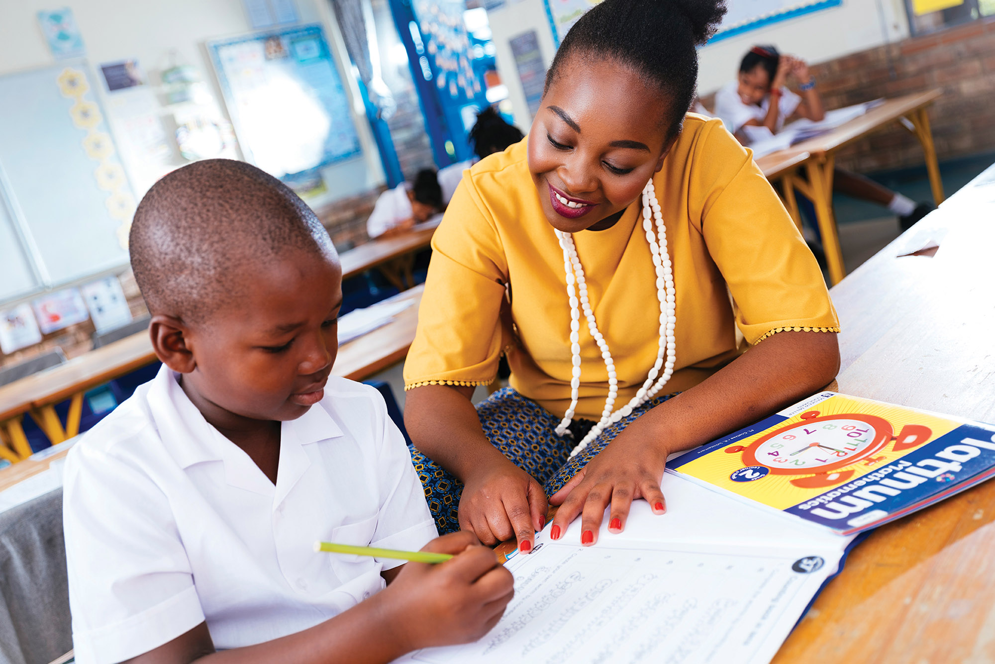 Teacher helping learner in class